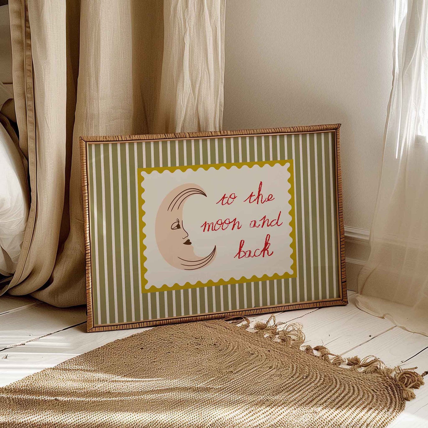 Framed artwork with a moon and text on a striped background, placed on a wooden floor.
