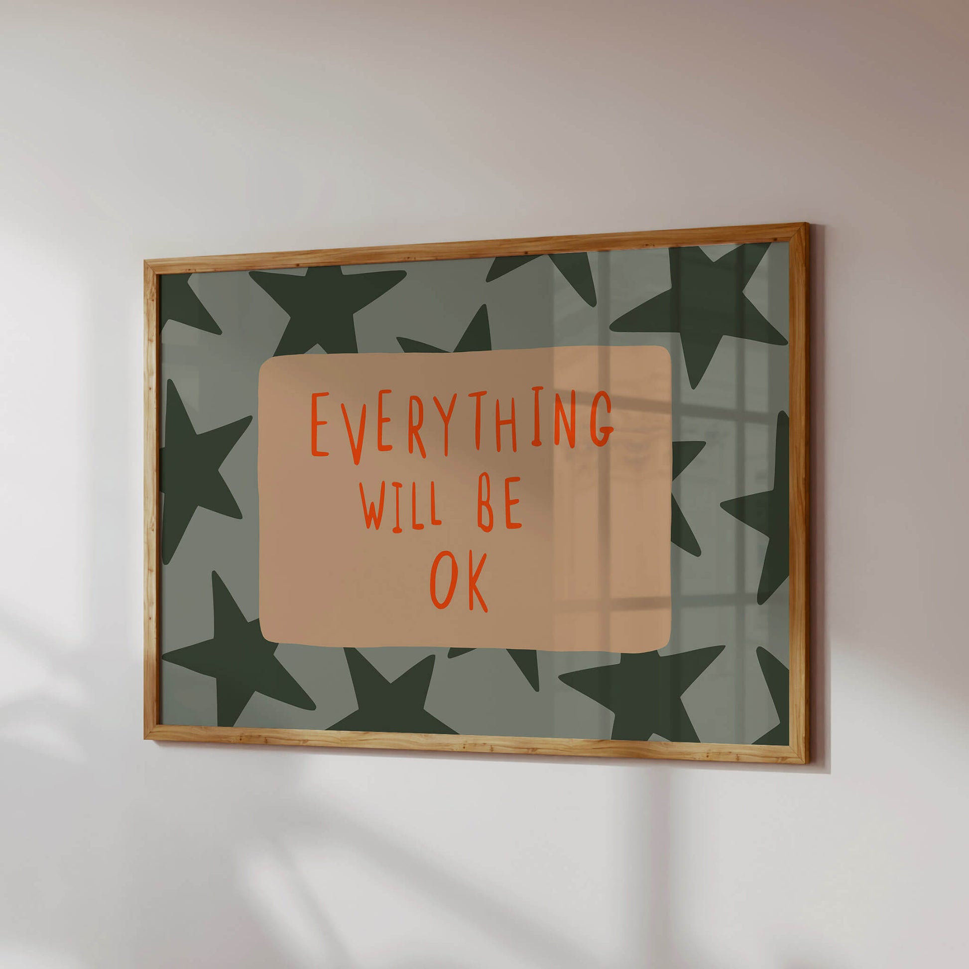 a framed poster with a green and orange star pattern and the text "EVERYTHING WILL BE OK" written in orange.