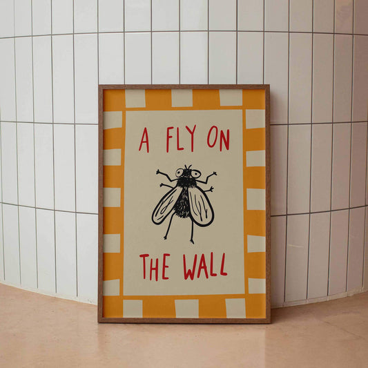 A framed poster with the text "A FLY ON THE WALL" and an illustration of a fly.