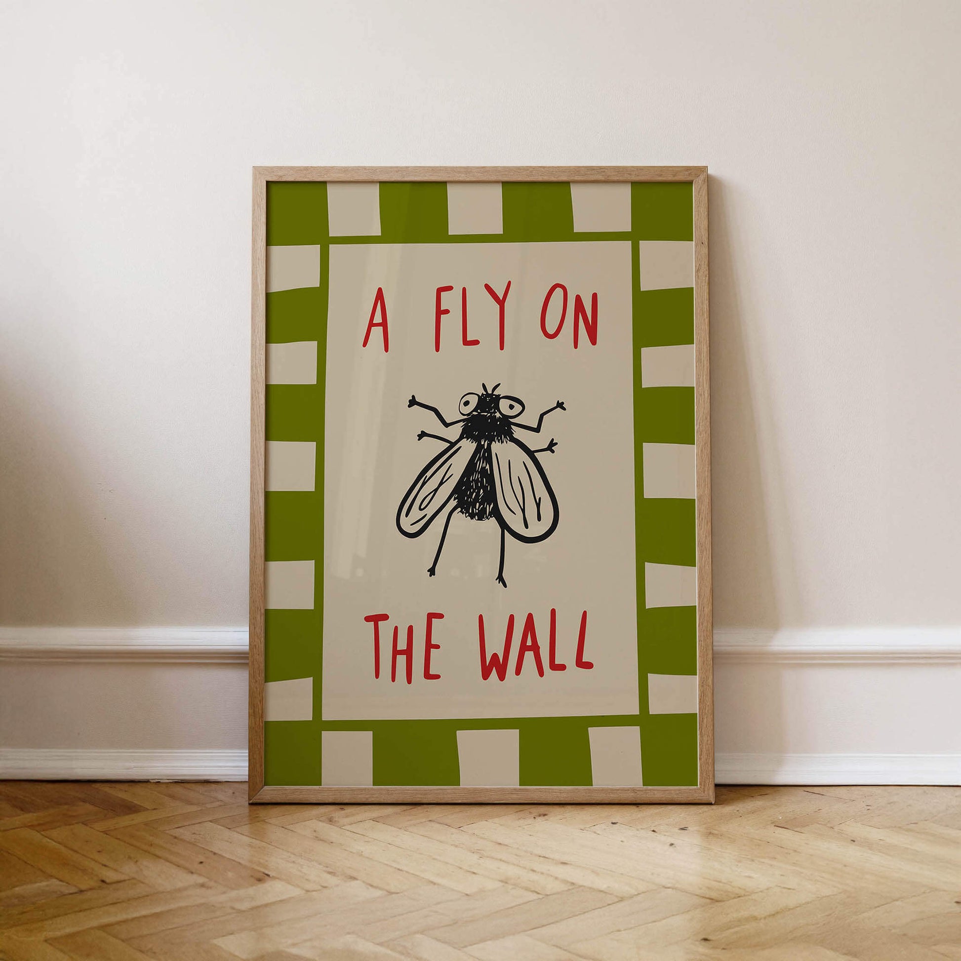 A framed poster with the text "A FLY ON THE WALL" and a black and white illustration of a fly.