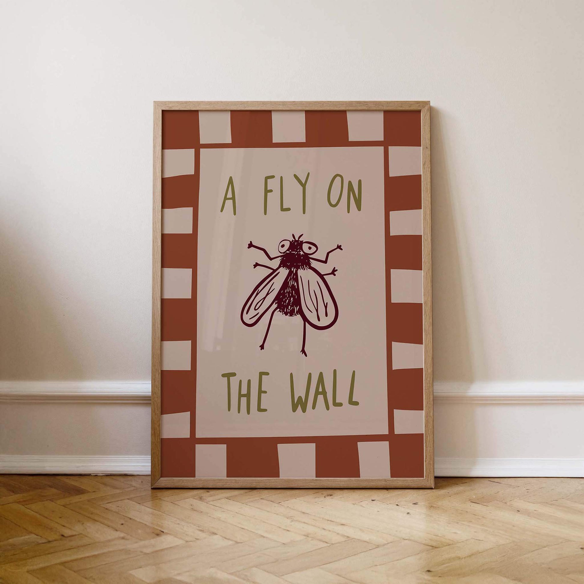 A framed poster with the text "A FLY ON THE WALL" and a graphic of a fly.