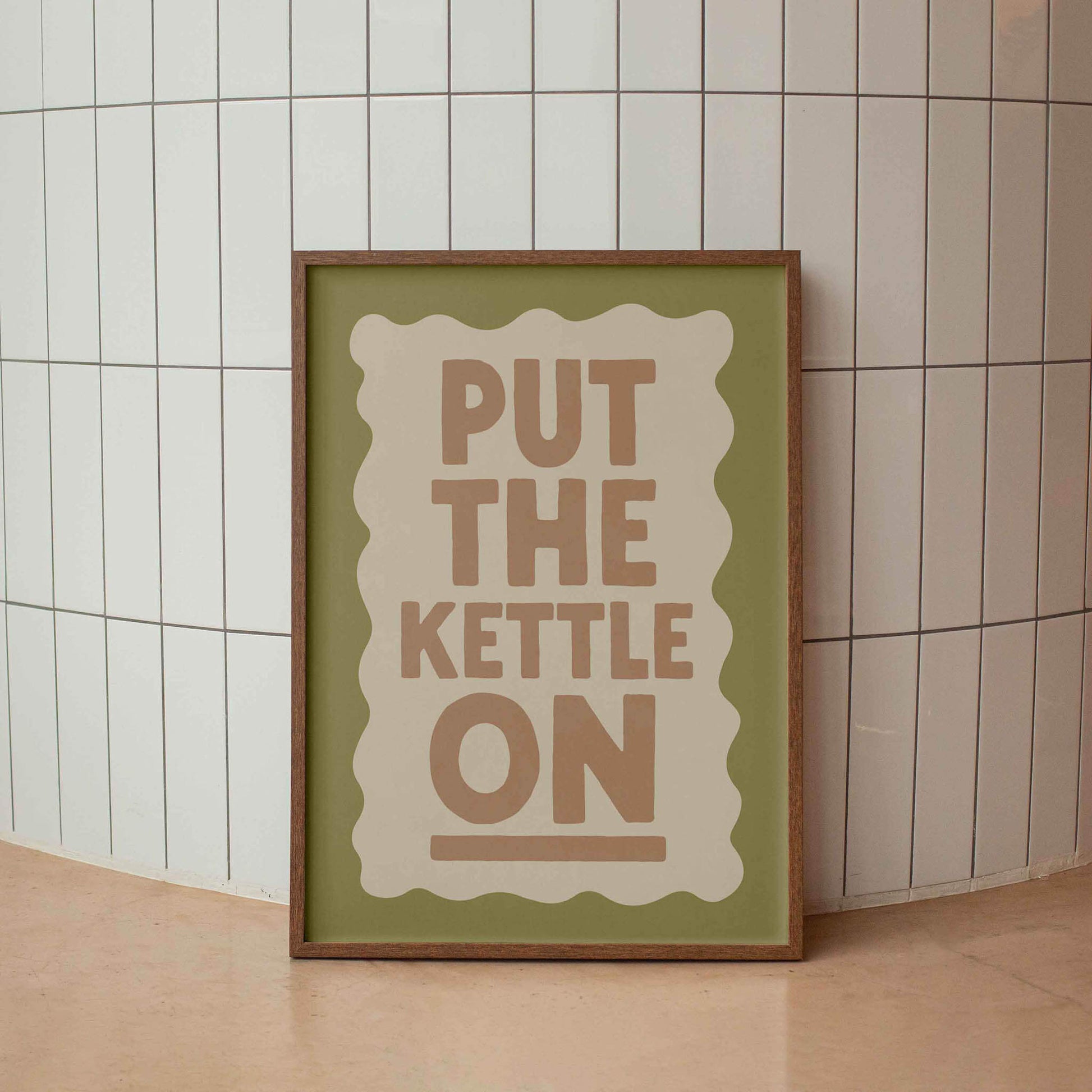 A framed poster with the text "PUT THE KETTLE ON" displayed prominently in the center.
