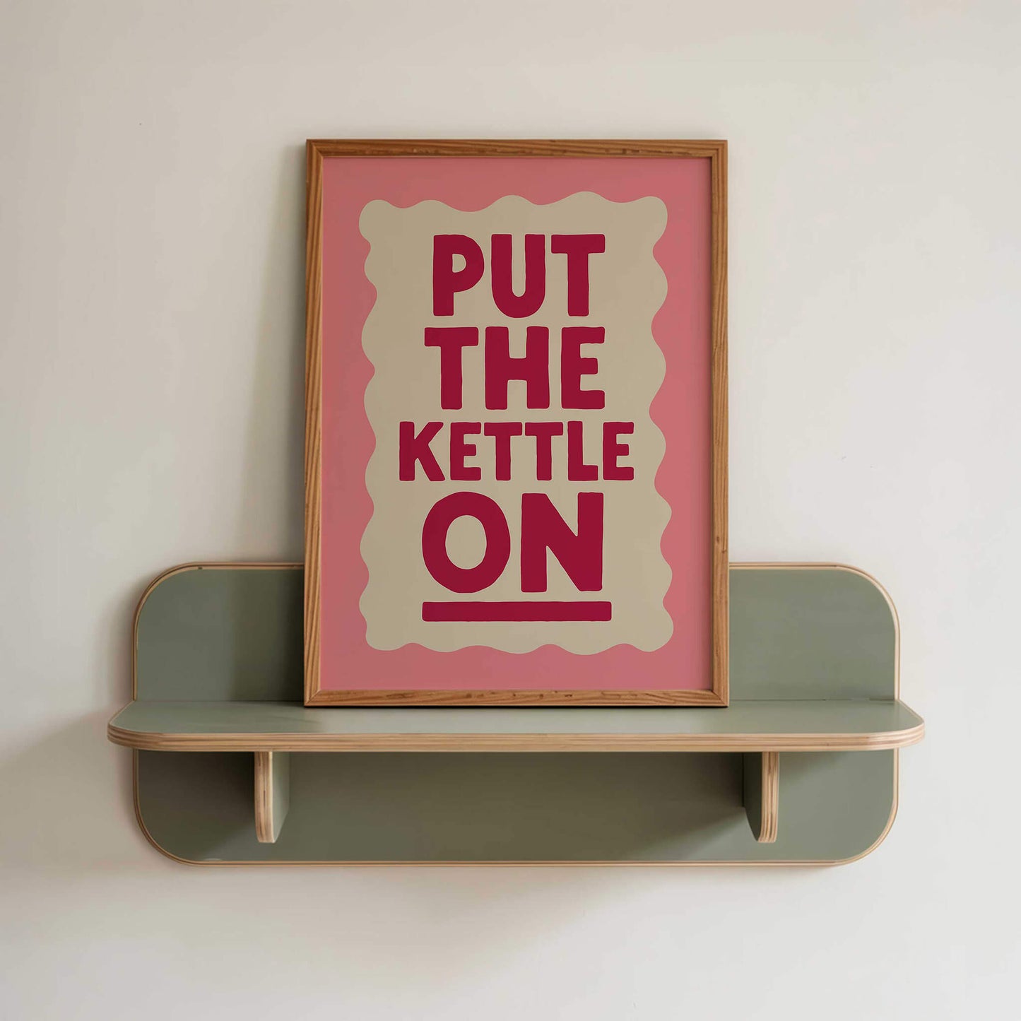 a pink framed poster with the text "PUT THE KETTLE ON" displayed on it.