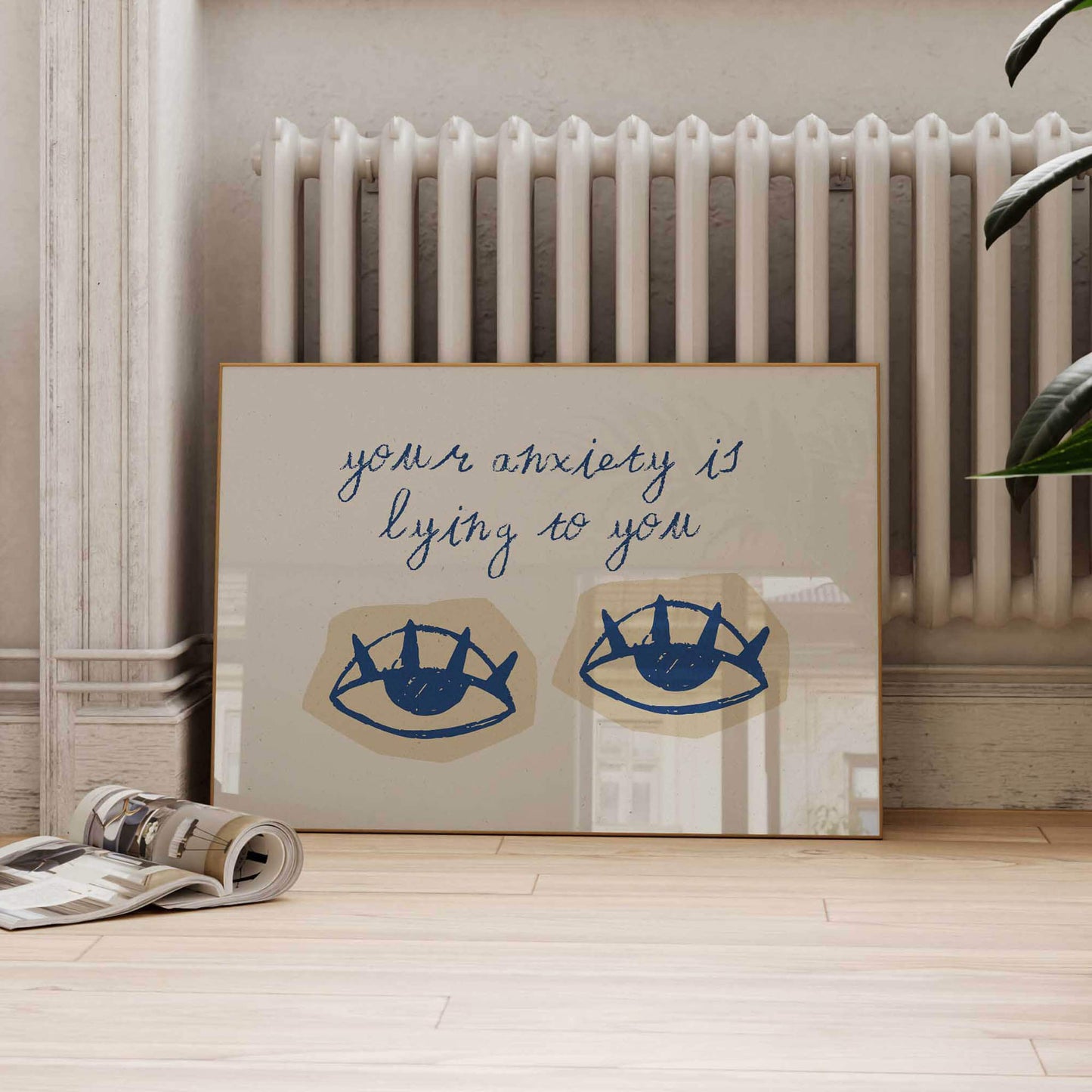 a framed artwork with a message about anxiety, placed on a wooden floor next to a radiator.