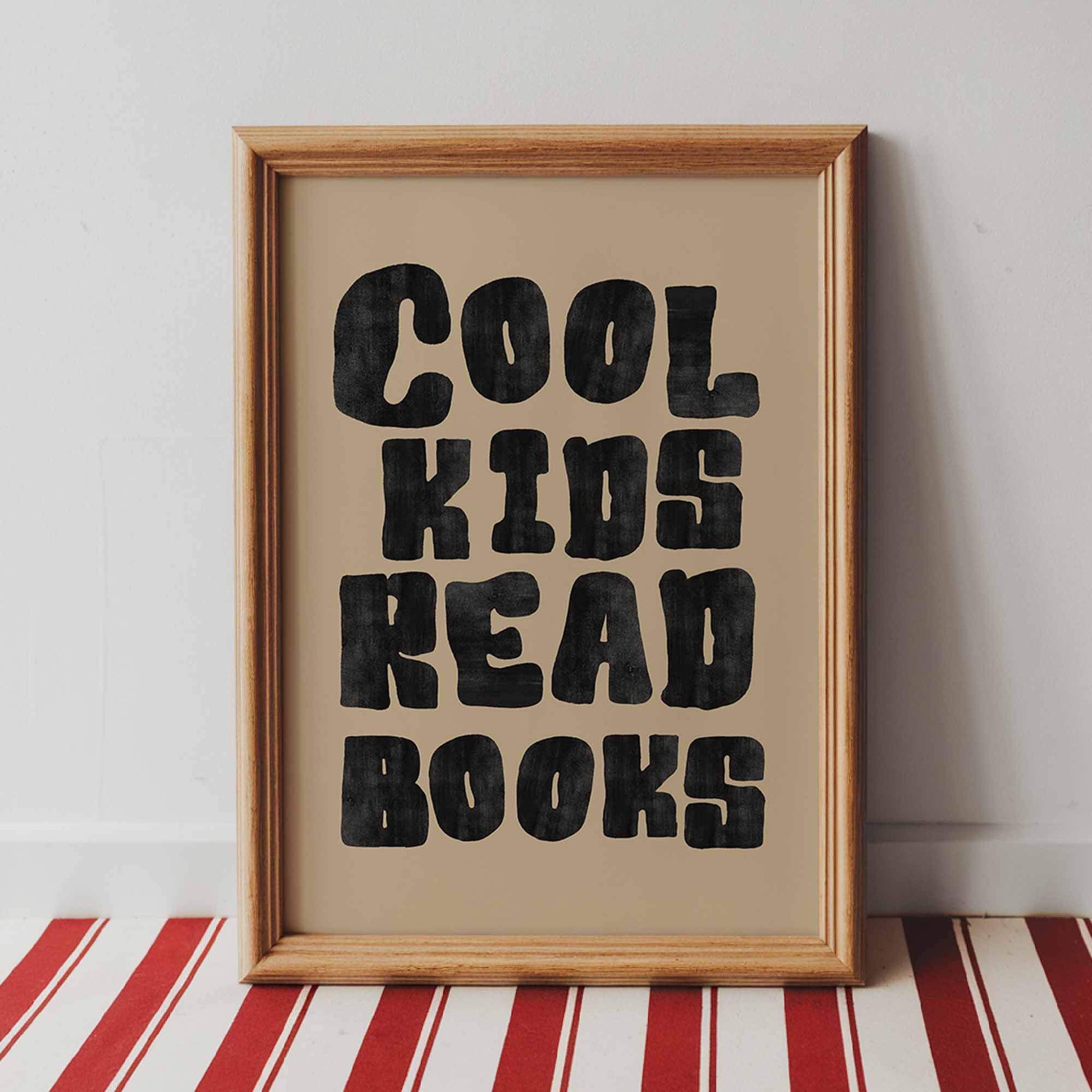 Framed poster with 'Cool kids read books' text on a striped surface.