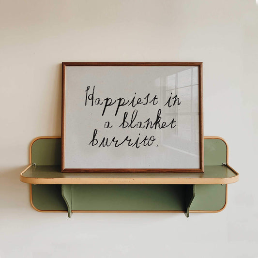 a framed quote that reads "happiest in a blanket burrito."